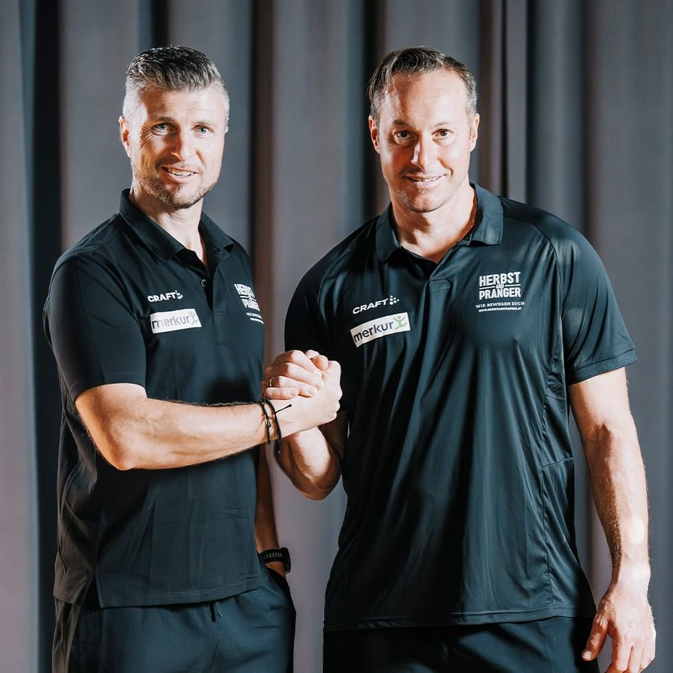 Two men in sports attire fist-bumping during active days with sports stars.