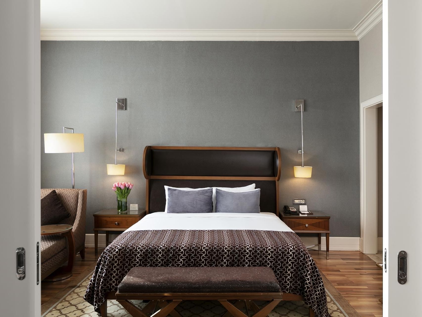 Titanic Business Kartal’daki Premier Suite’te, rahat yastıklarla donatılmış çift kişilik yatak ve komodinler.