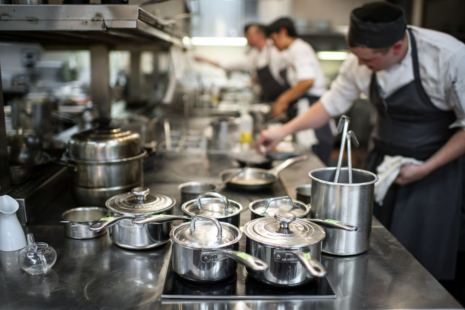 Chef handling pots and pans in the kitchen at Umstead Hotel and Spa