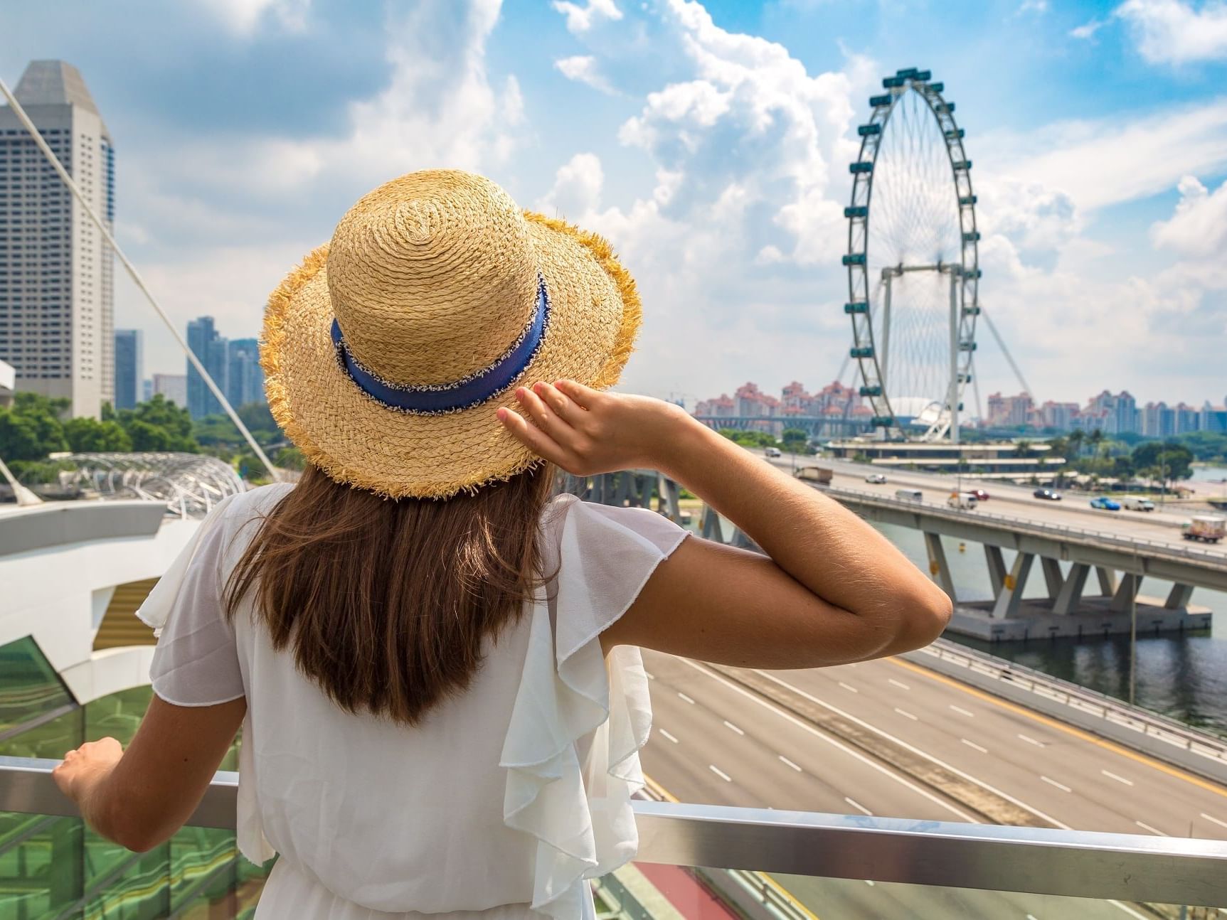 Woman in straw hat admiring cityscape near Paradox Singapore