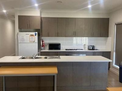 Modern kitchen with white appliances, gray cabinets, and white counters in La Trobe University Regional Housing – Mildura.