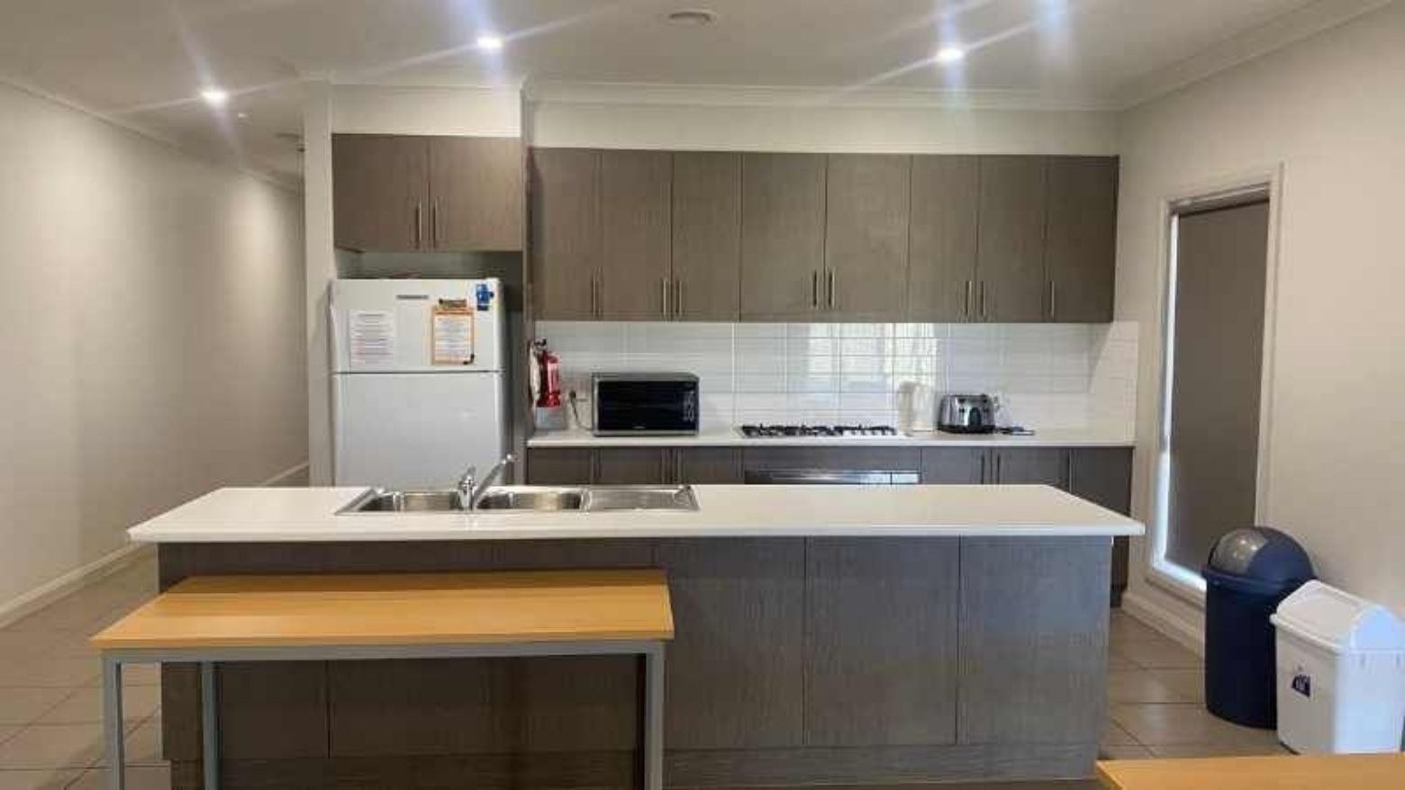 Modern kitchen with white appliances, gray cabinets, and white counters in La Trobe University Regional Housing – Mildura.