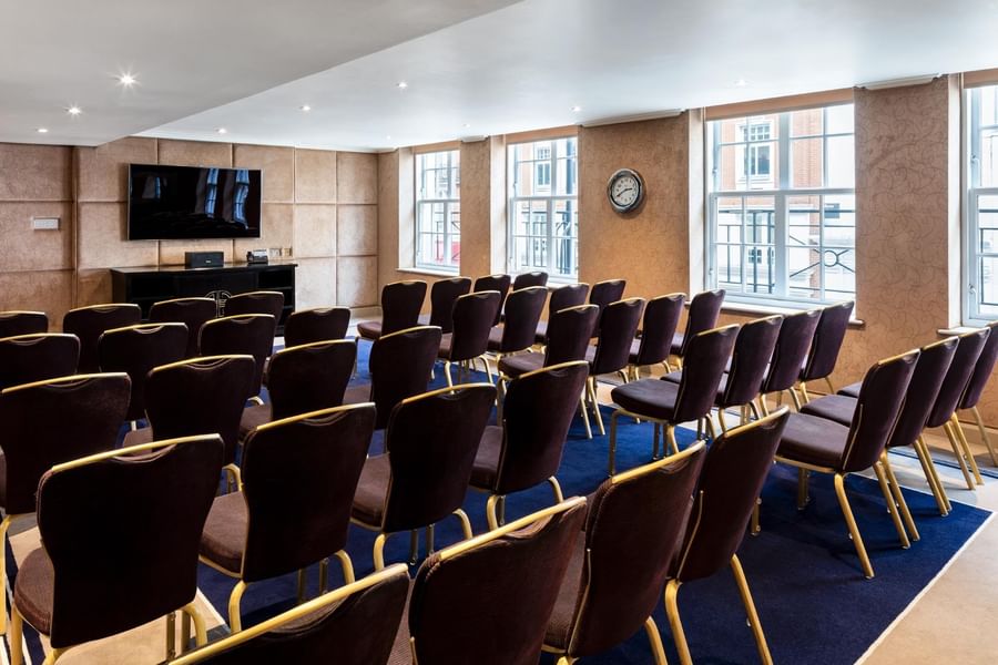 Theatre-style meeting room arrangement with TV in a private suite at The May Fair Hotel