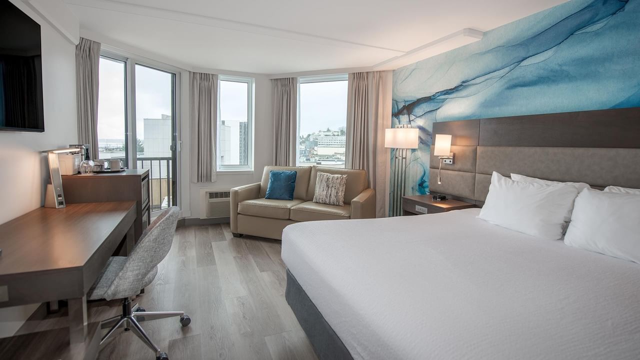 Coast Accessible King room with a large bed, sofa, desk, and balcony at Coast Bastion Hotel in Nanaimo.