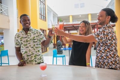 3 people toasting in De Lobby Bar at Holiday Inn Montego Bay