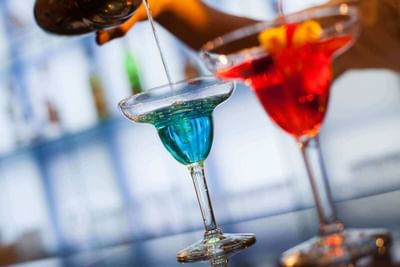 Two refreshing cocktails with colorful garnishes served at Marigold Bar in Park Hotel Hong Kong