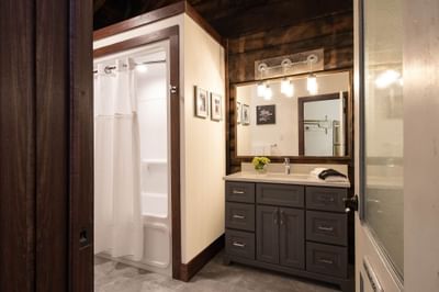 Bathroom with vanity & large mirror in Apartment 402 at Retro Suites Hotel