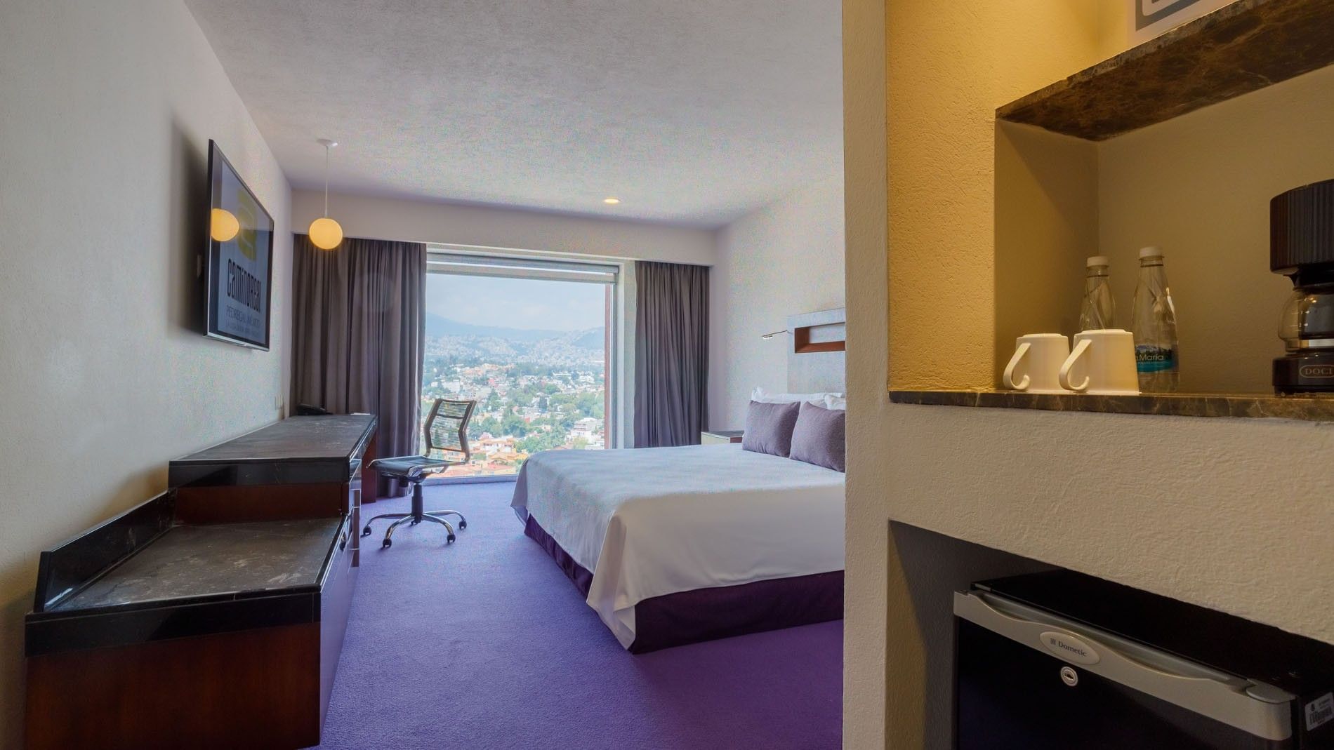 King Deluxe room showing a king bed and a high-rise view of the city landscape at Camino Real Pedregal Mexico