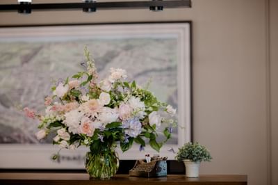 Lush floral bouquet sitting beside a miniature typewriter prop on the front counter at La Tourelle Hotel and Spa