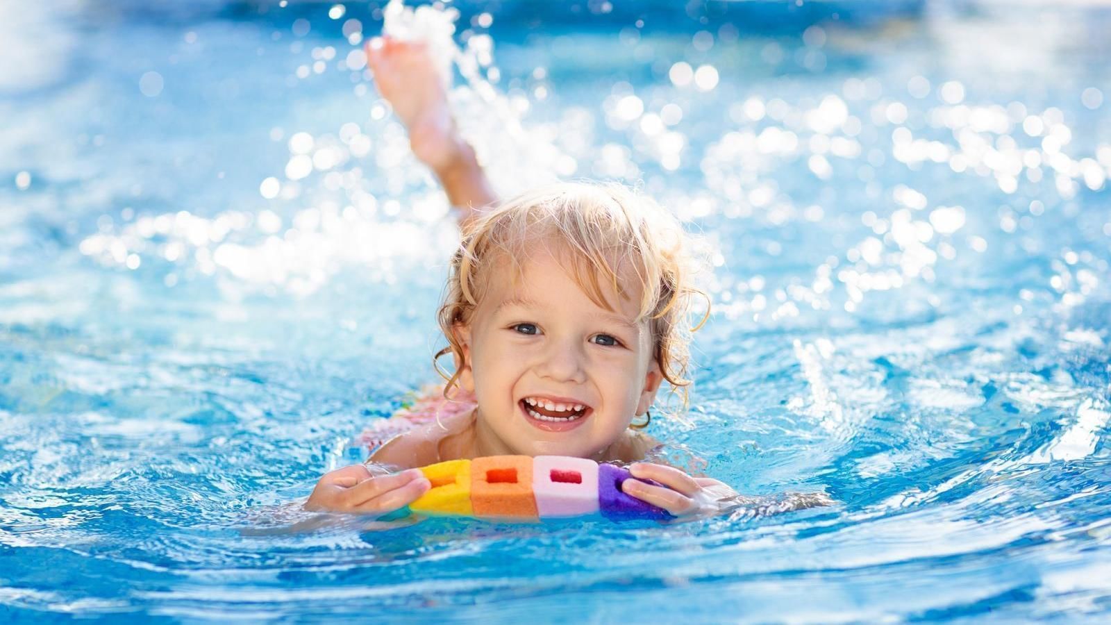 A happy kid swimming in pool at FA Hotels & Resorts