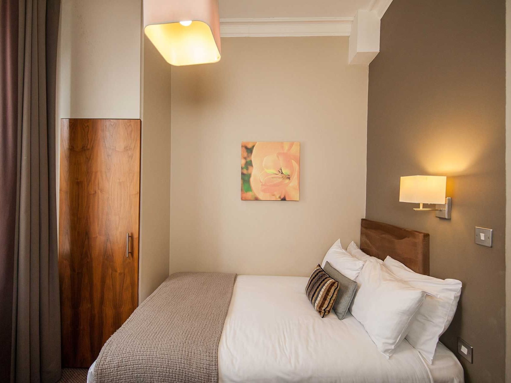 Wall lamp over a queen bed in Cosy Double Room at The Met Hotel