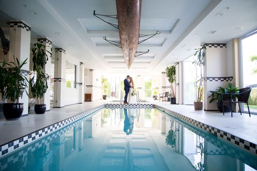 Wedded couple posing by the indoor pool at Hotel Eldorado