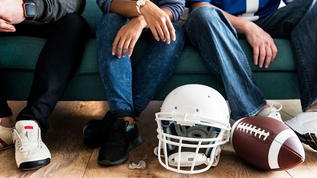 Legs on couch with football and helmet