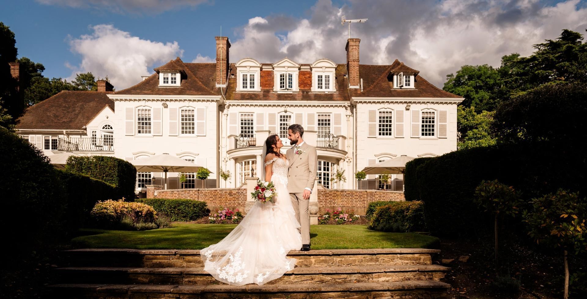 Married couple outside Gorse Hill Mansion offering some of the best weddings in Surrey
