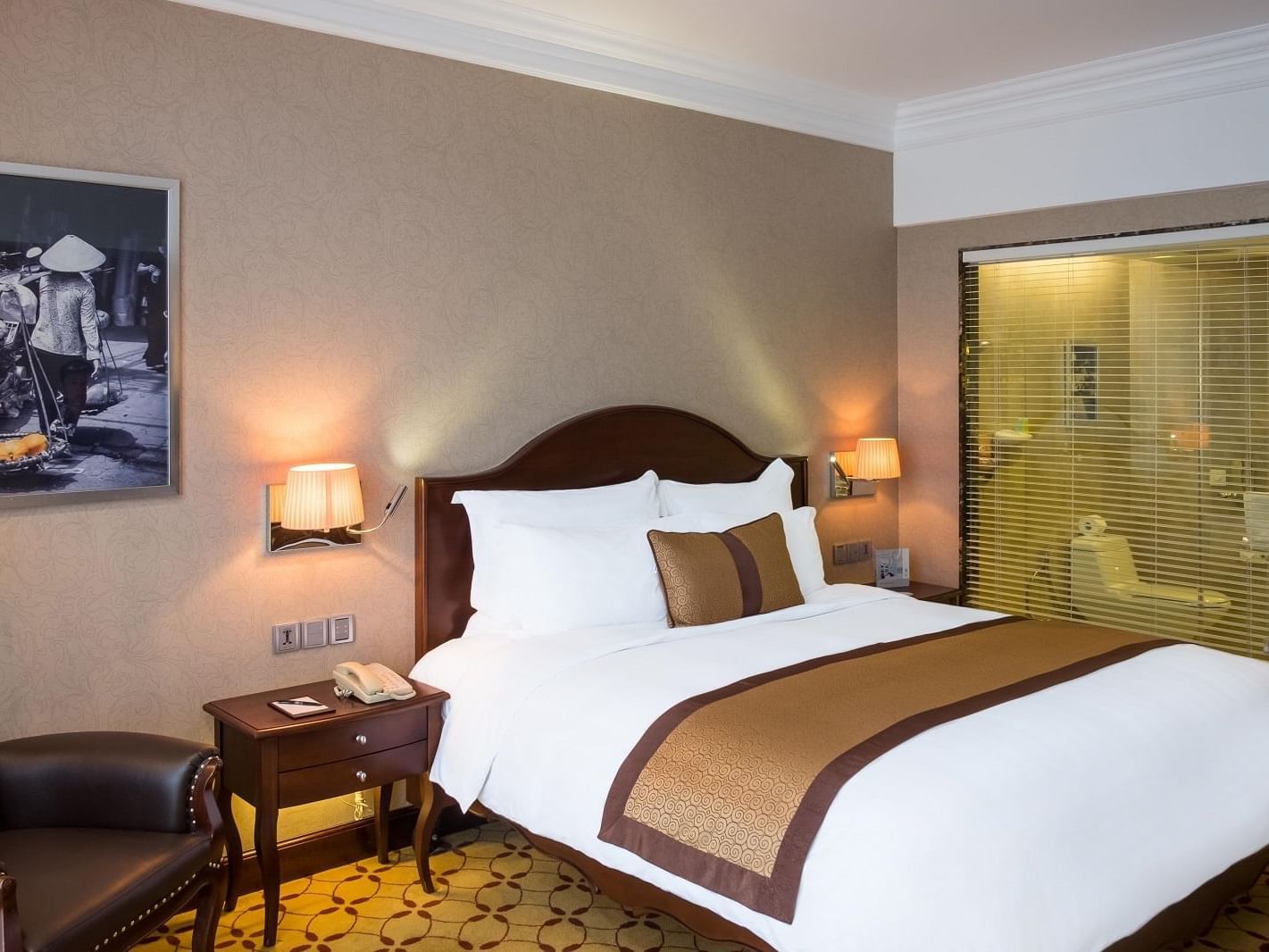 Club Premium Deluxe with a king size bed & a comfy chair at Eastin Grand Hotel Saigon