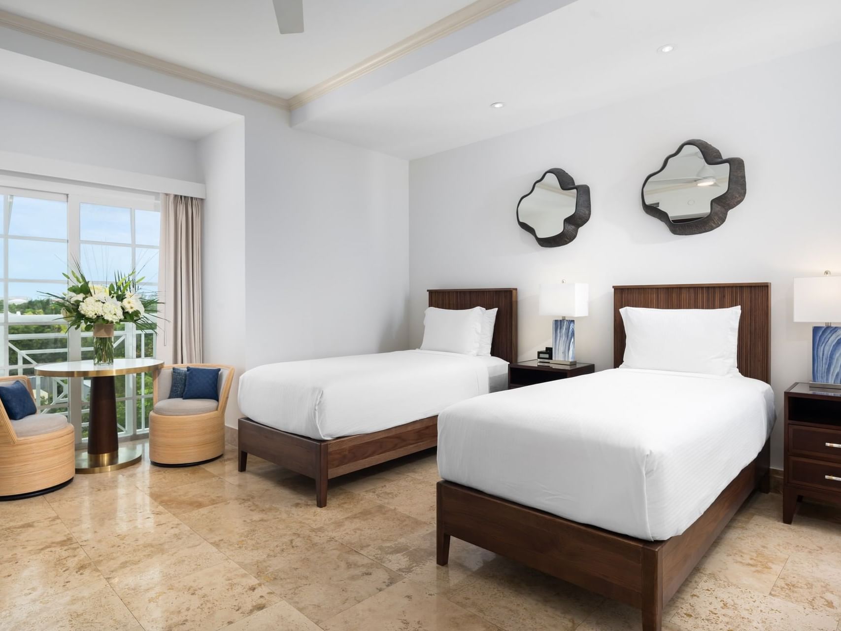 Bright studio with two twin beds, cozy seating, elegant decor, and large windows at Windsong Resort On The Reef
