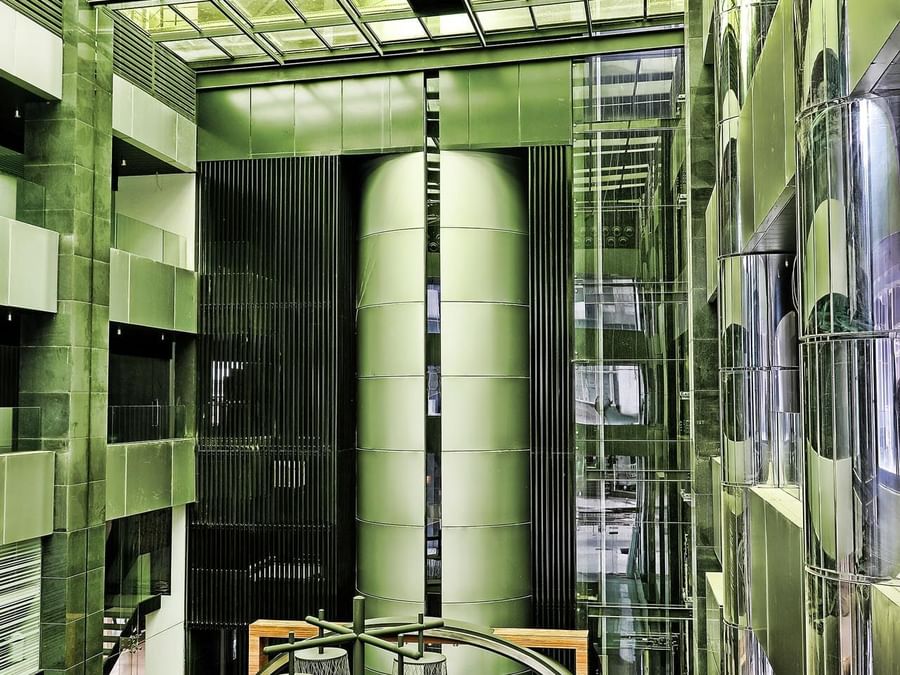 Glass elevators by metallic pillars under a vaulted glass ceiling in the atrium at Warwick Stone 55 - Beirut