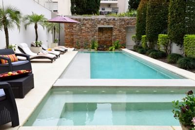 Piscina exterior con hamacas en Argenta Suites Belgrano