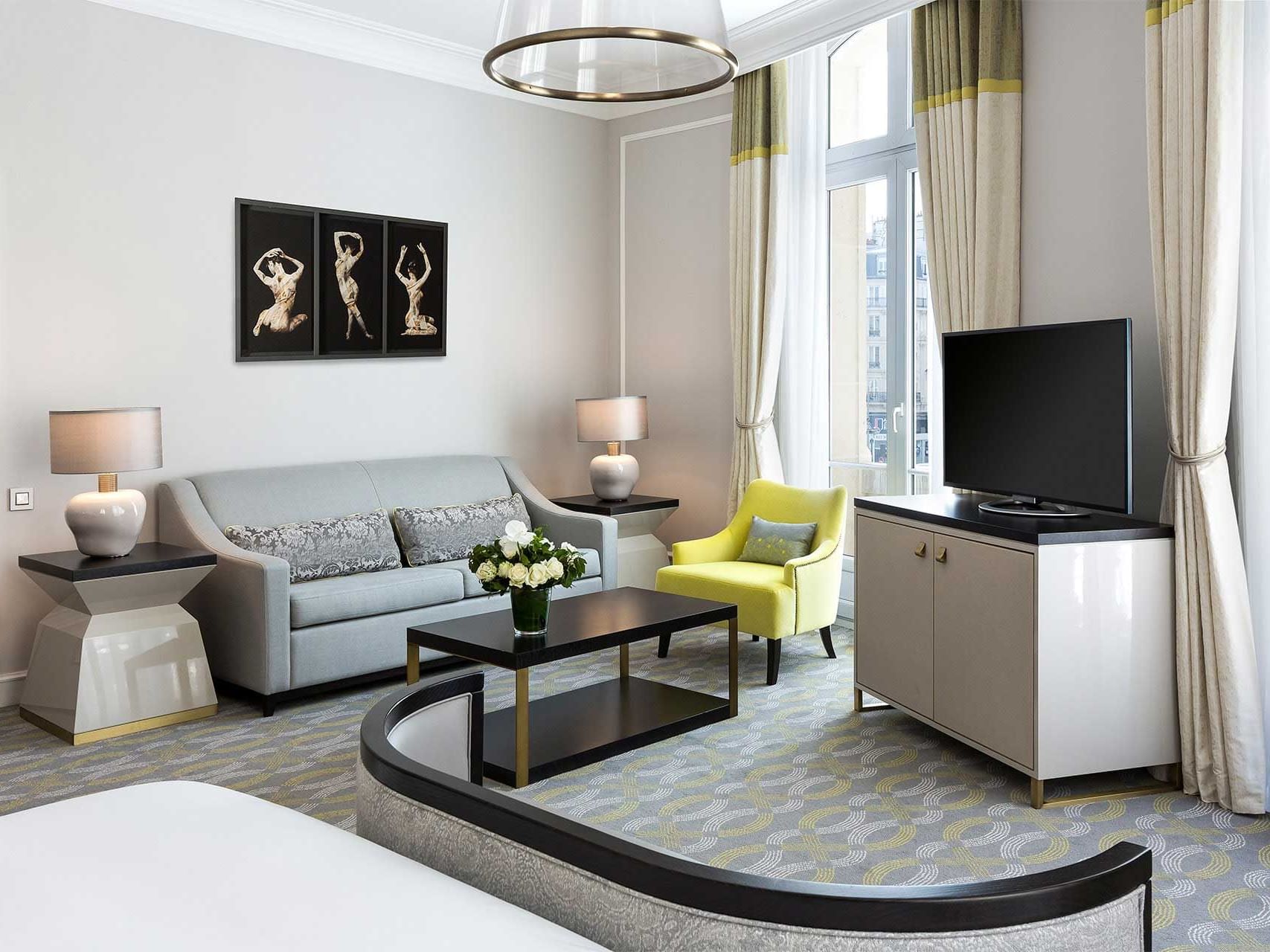 Tv and sofa in King Master Suite at Hilton Paris Opera Hotel