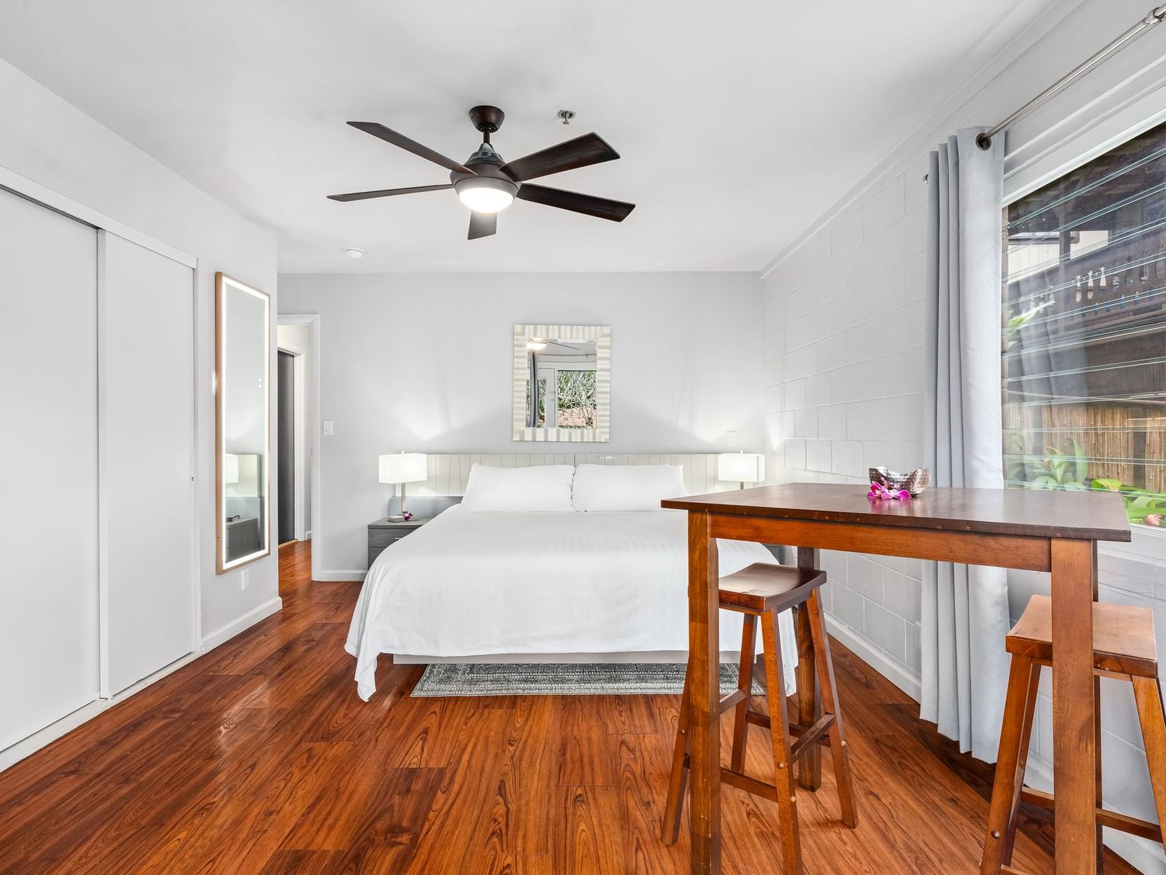 Comfy bed & wooden floors in Studio Suite Classic at Paradise Bay Resort