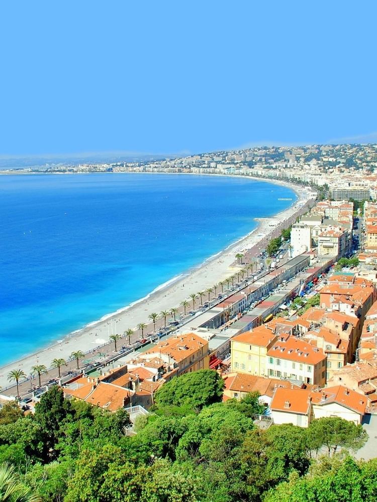 Stunning panoramic view of the sunny Nice coastline with blue water and city homes near Splendid Hotel & Spa Nice
