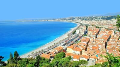 Stunning panoramic view of the sunny Nice coastline with blue water and city homes near Splendid Hotel & Spa Nice