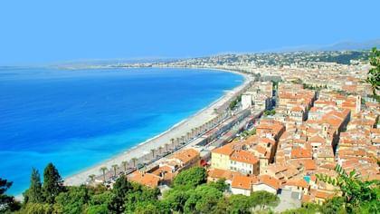 Stunning panoramic view of the sunny Nice coastline with blue water and city homes near Splendid Hotel & Spa Nice
