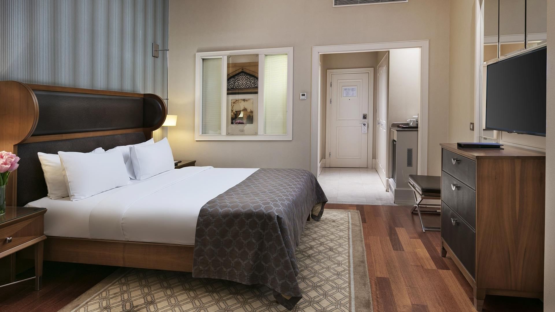 Comfy bed and TV with wooden carpeted floor in Superior Room at Titanic Business Kartal