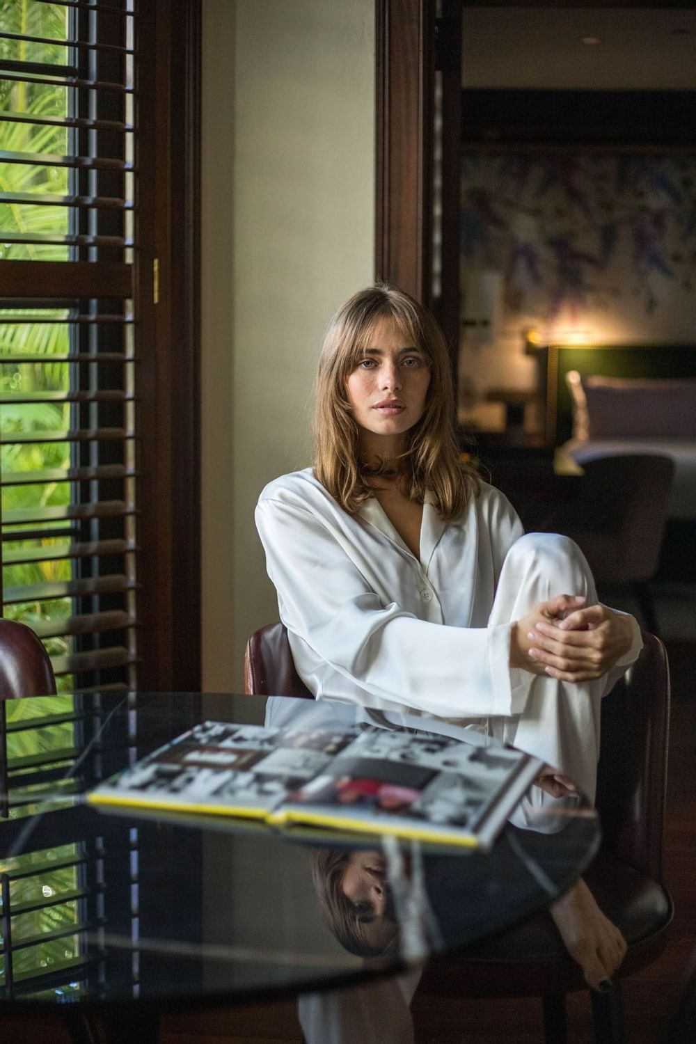 A woman sitting on a chair in a hotel room at Brazilian Court 