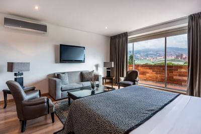 habitacion cama king con sofa cama y TV