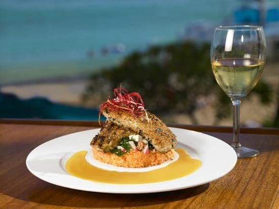 Exquisite dish served with a champagne glass in Hula Grill Waikiki near Waikiki Resort Hotel