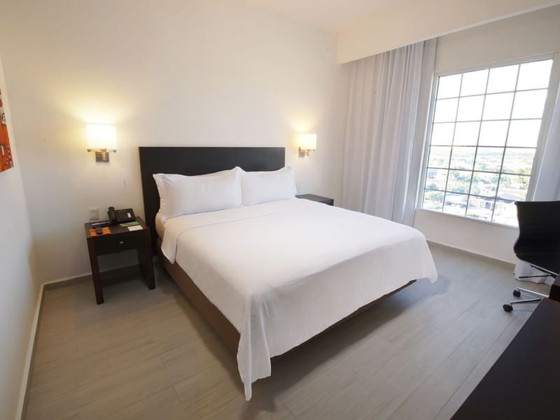 King bed in Superior Room with furniture at Fiesta Inn