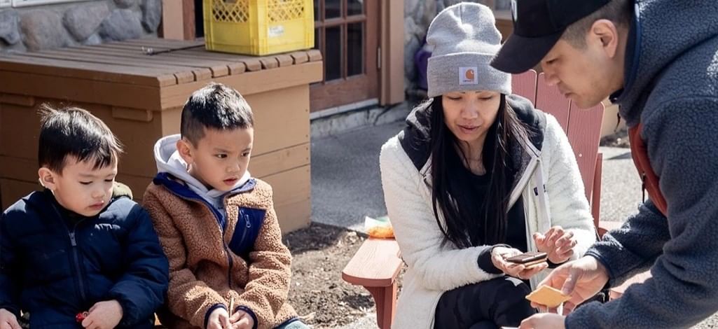 A family enjoys eating S'Mores at the Coast Canmore Hotel & Conference Centre.