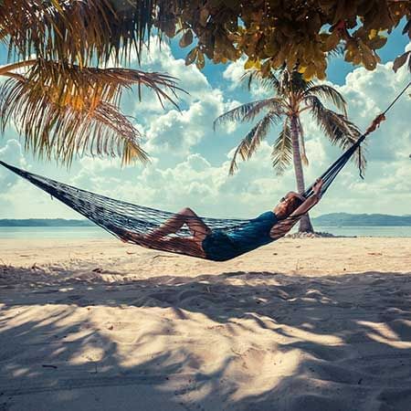 a person lounging on a hammock at a beach with a seaside view - Lexis Port Dickson