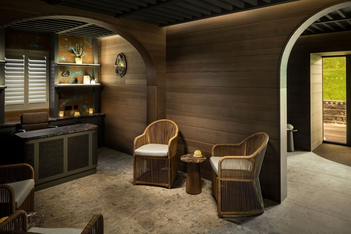A spa relaxation room with natural tones, a stone floor, and arched doorways at Dunluce Lodge