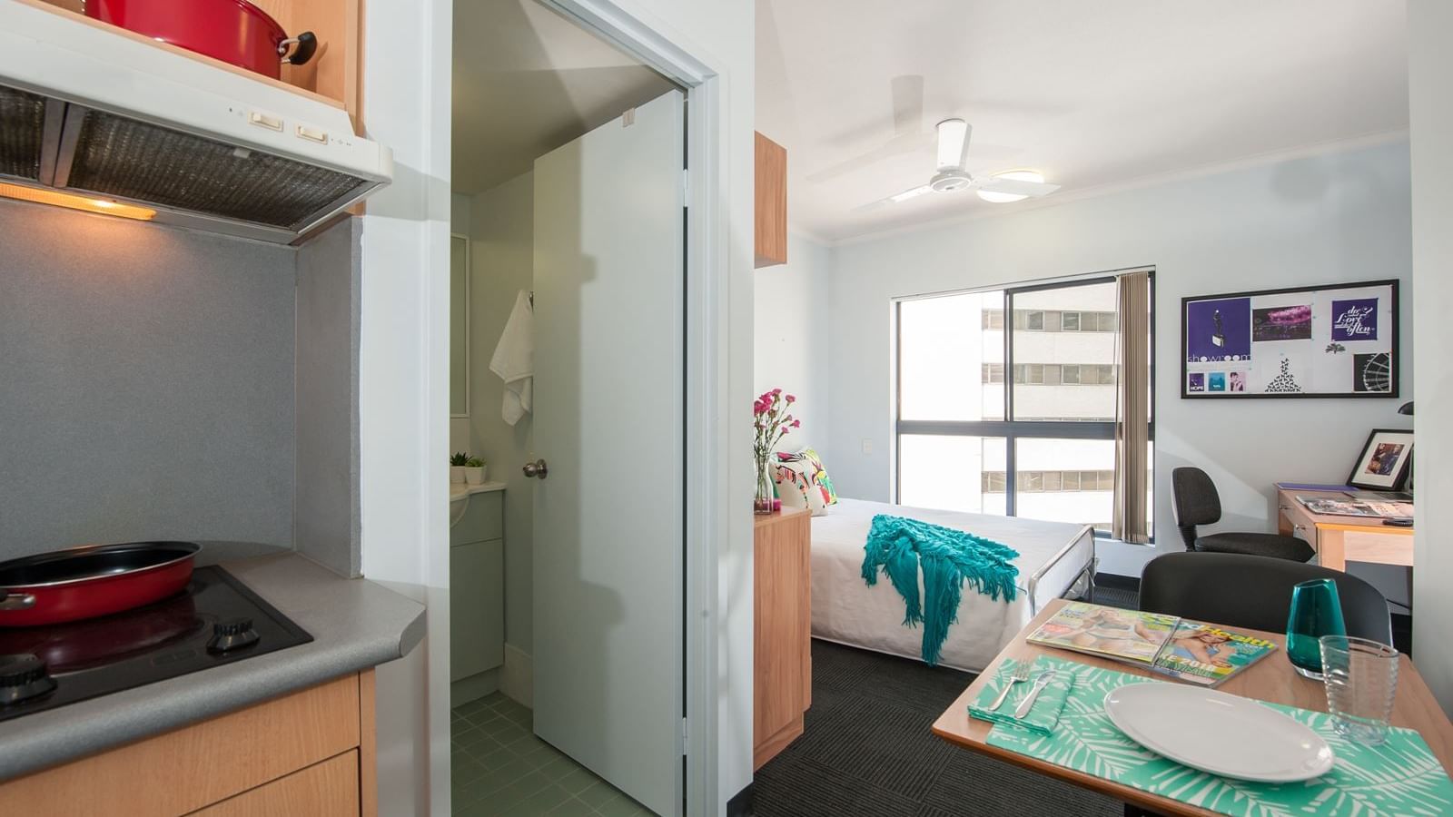Modern studio apartment with kitchenette, bathroom, single bed, desk, and ceiling fan at StudentLiving - on Margaret