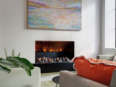 Modern lounge with electric fireplace, colorful artwork, and comfortable seating at UniLodge Auckland Central