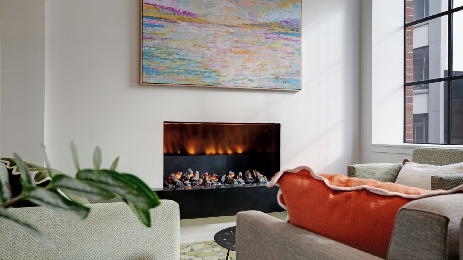Modern lounge with electric fireplace, colorful artwork, and comfortable seating at UniLodge Auckland Central