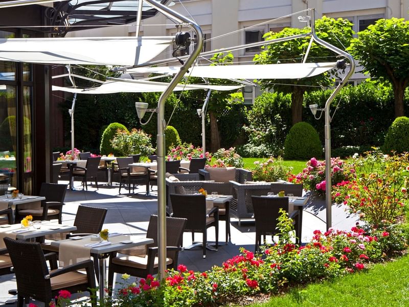 Dining tables arranged outdoors on a sunny day at Warwick Reine-Astrid