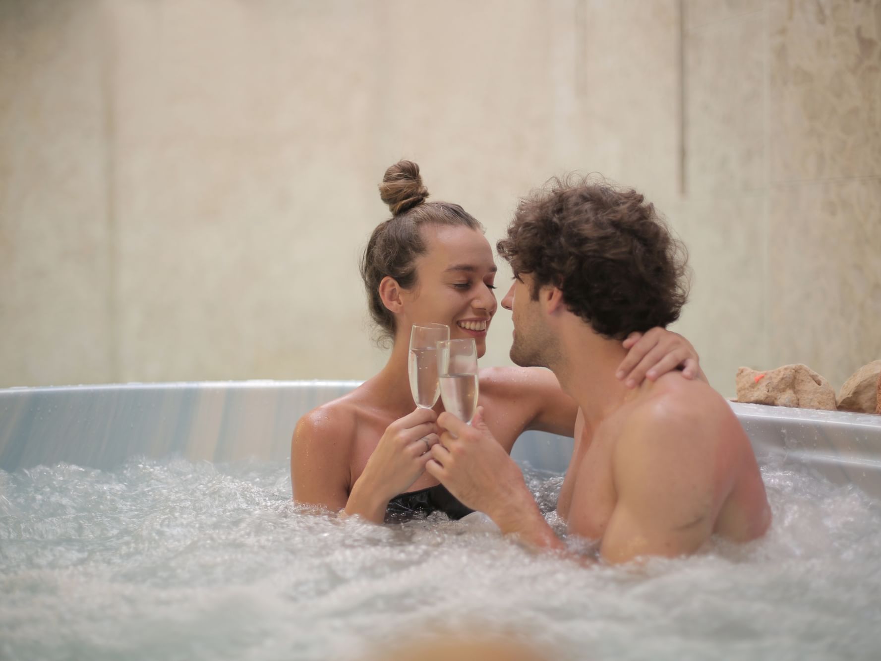 A couple on a hot tub toasting champagne at Originals Hotels