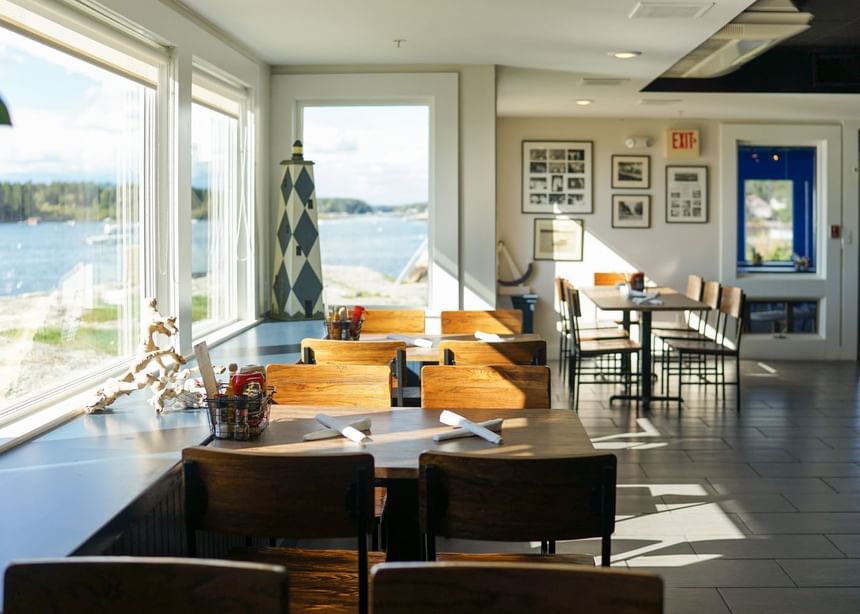 Arranged dining area with a sea view from windows in Ledges Pub at Sebasco Harbor Resort