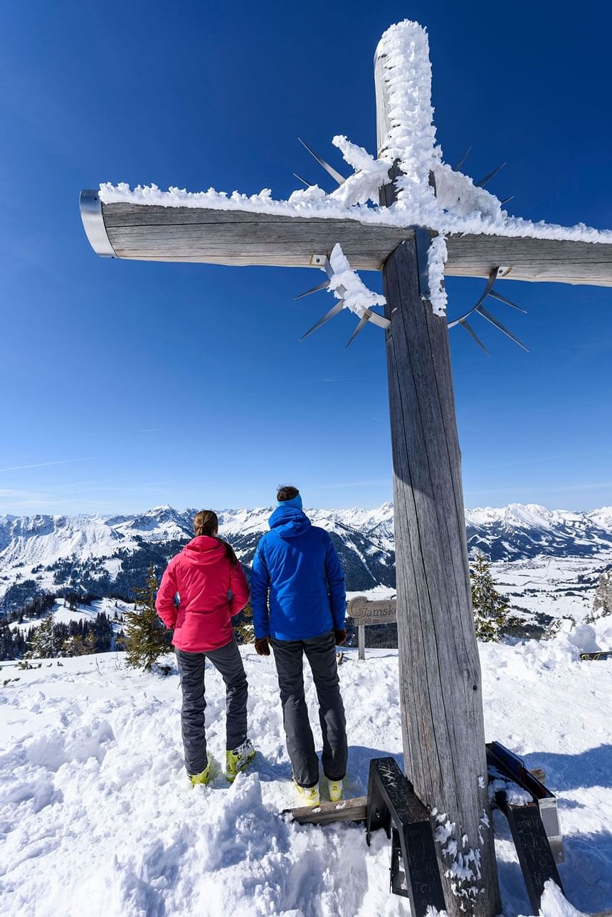 A couple by a Summit Cross in Tannheimer Valley near Liebes Rot