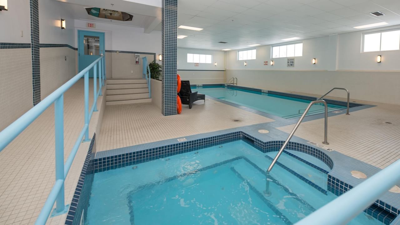 Hotel indoor pool with hot tub .