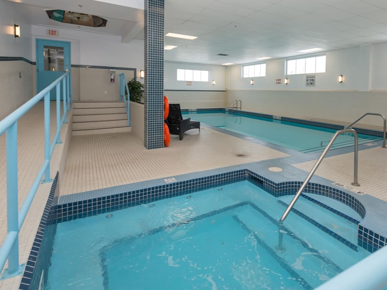 Hotel indoor pool with hot tub .