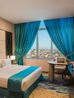 TV facing the bed with a work desk near window in Executive suite at Naviti By Warwick Dammam