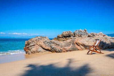 Single deck chair on Maraika Beach with sea near Villa Premiere Boutique Hotel & Romantic Getaway