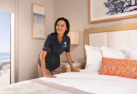 Maid arranging a bed for people at Sunseeker Resort