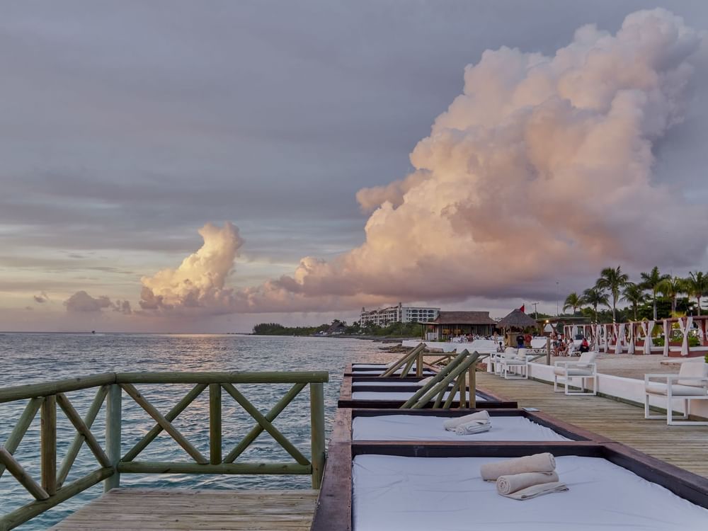 Hammock beds lined by the sea at sunset near Explorean Brand