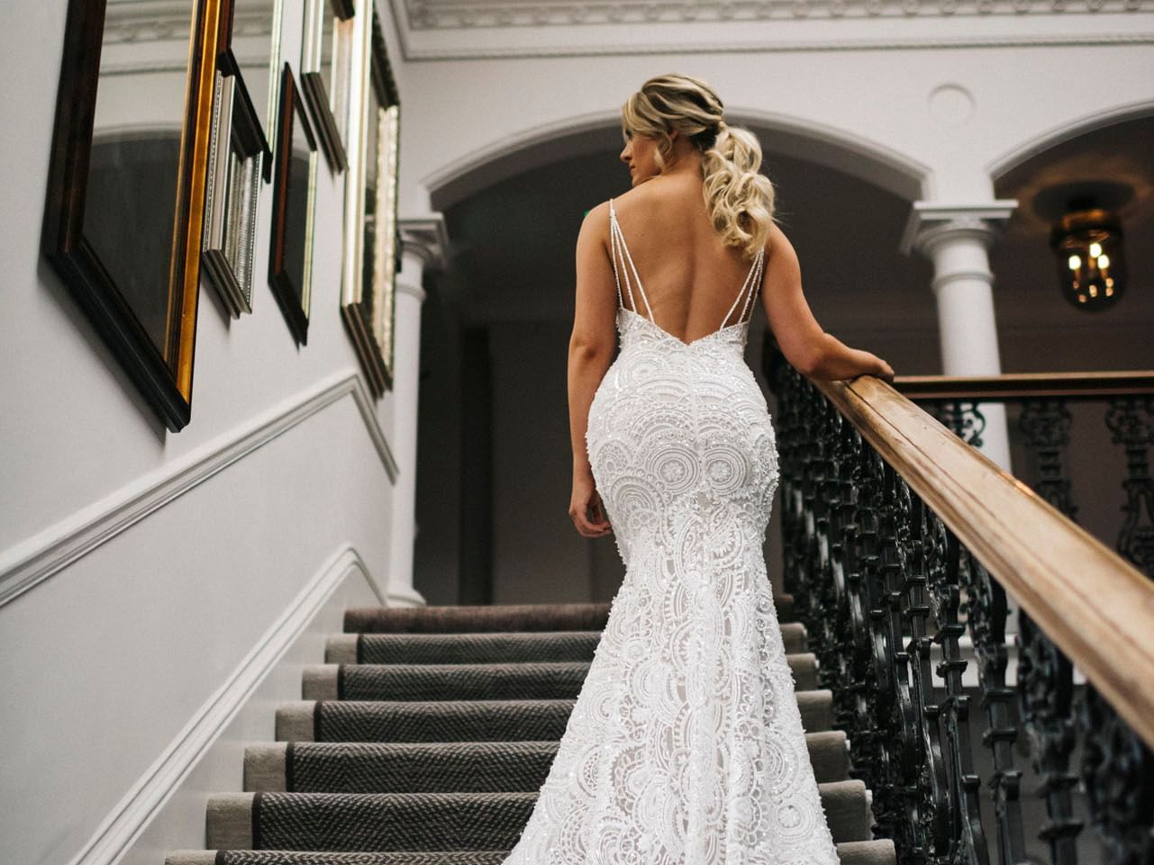 Bride in a white lace wedding dress posing on the stairway at The Milner York