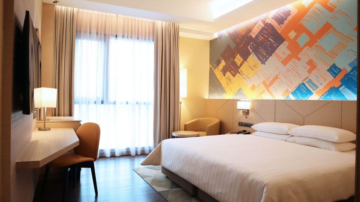 king bed, single sofa, and a TV in Premier King Room at Sunway Hotel Seberang Jaya